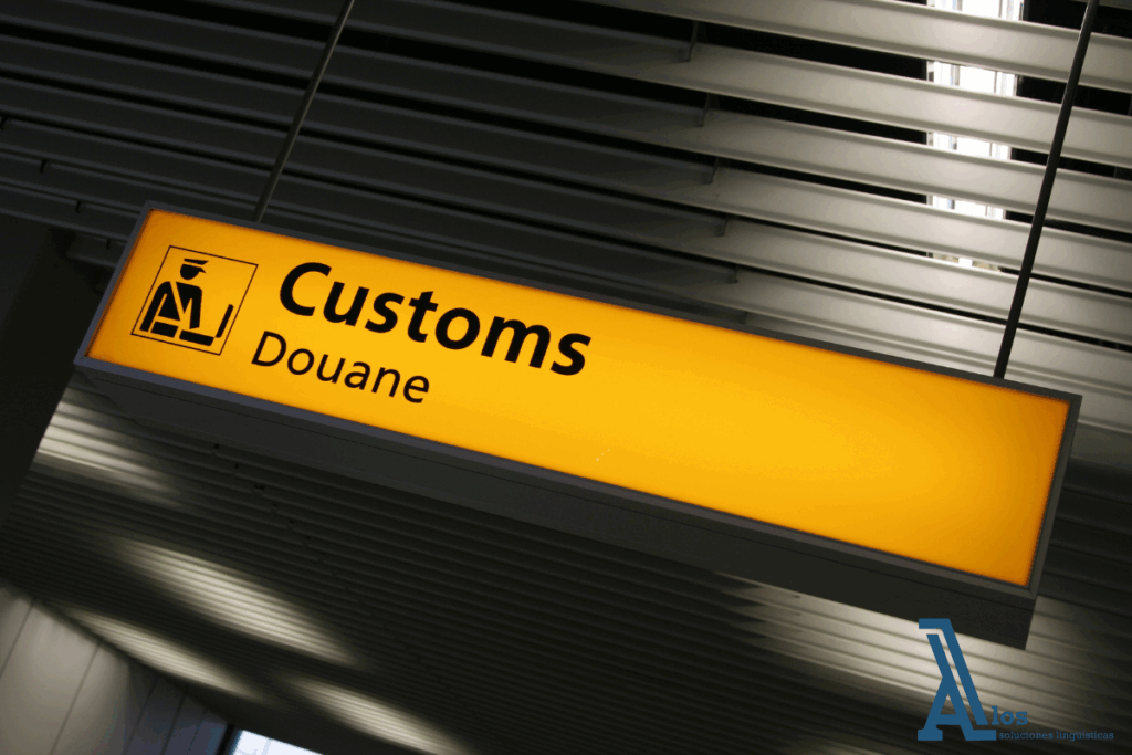 Cartel con la palabra “Customs” en la entrada de una oficina aduanera, representando el control fronterizo en operaciones internacionales. La imagen ilustra la relevancia de una correcta traducción de documentos aduaneros para evitar problemas en la importación y exportación de mercancías.