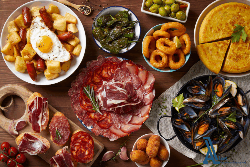 Plato variado de tapas españolas con embutidos, mariscos, tortilla, aceitunas y calamares, representando el contexto gastronómico del inglés para turismo y hostelería.

