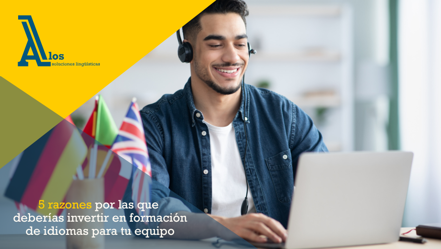 Joven profesional estudiando idiomas en su portátil junto a una taza con banderas de varios países para mejorar su perfil laboral.