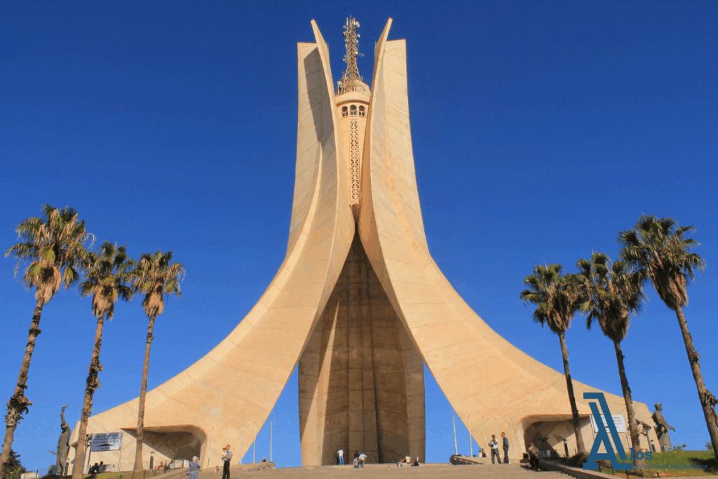 Monumento de los Mártires en Argelia, vista frontal de la torre con forma de palmas entrelazadas bajo cielo despejado.