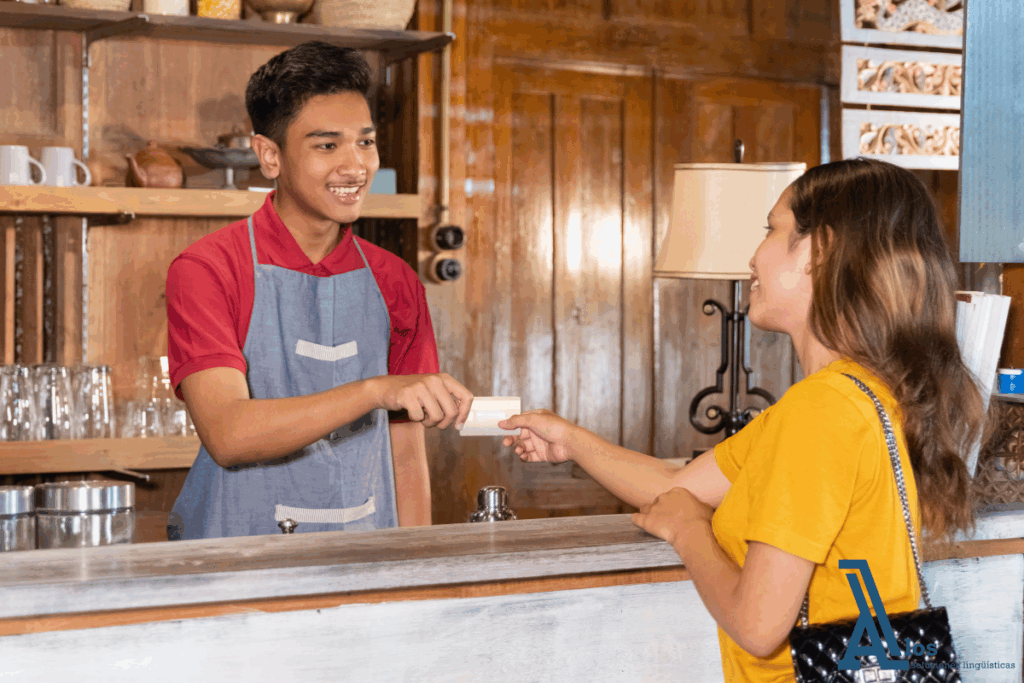 Empleado atendiendo cordialmente a una clienta en recepción, ilustrando una situación de uso del inglés para atención al cliente y ventas en un entorno profesional.